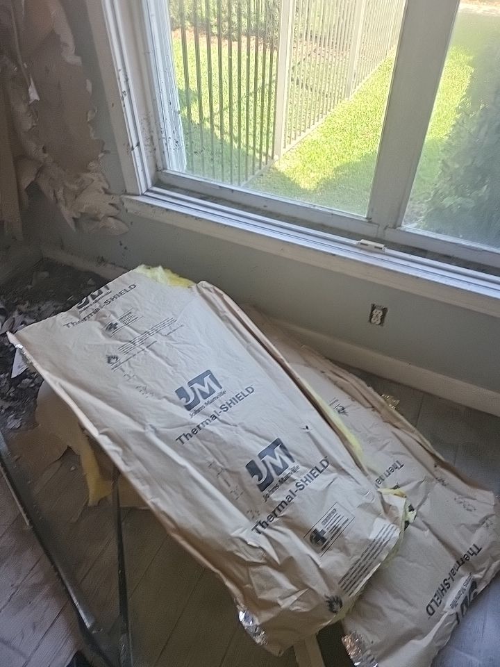Insulation and debris on floor after fire damage wall demolition